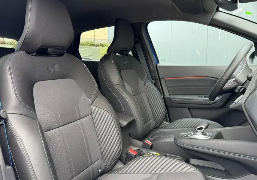 Vue intérieure côté droit du Renault Captur Esprit Alpine 2025, sièges tissu noir avec logo Alpine brodé.