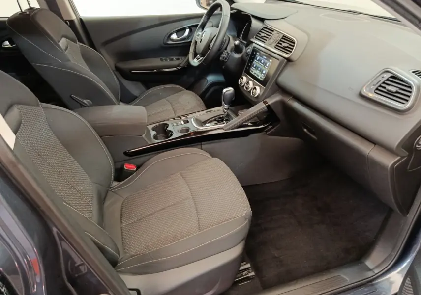 Vue intérieure côté passager du Renault Kadjar Business Blue dCi 115 EDC 2022, sièges tissu gris et console centrale noire.