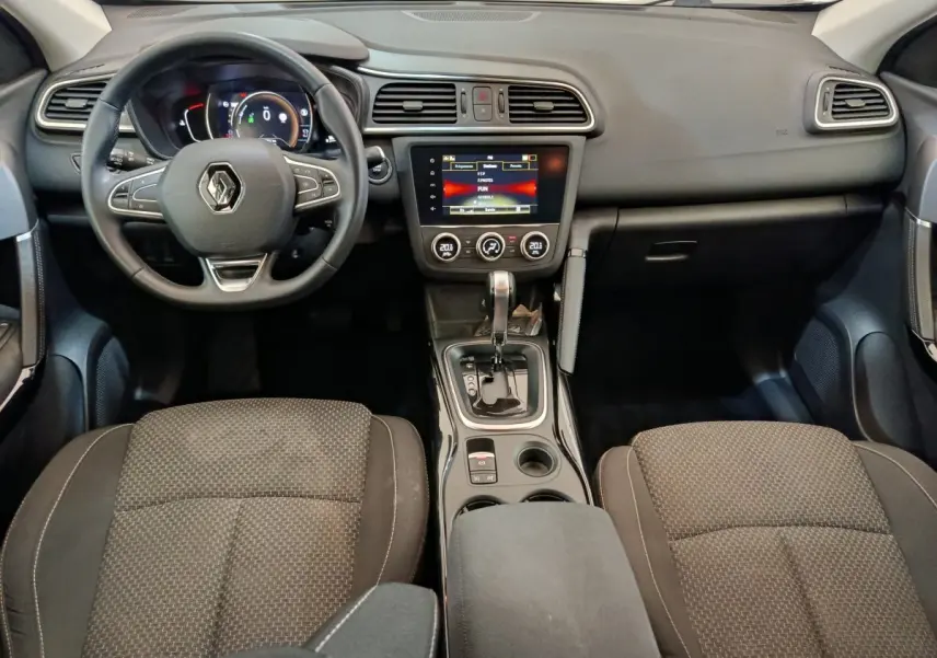 Vue intérieure avant du Renault Kadjar 2022 Business Blue dCi, tableau de bord avec écran tactile et volant multifonctions noir.