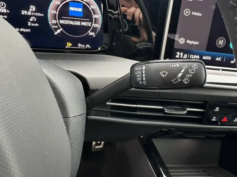 Gros plan sur la commande d’essuie-glace à gauche du volant dans l’habitacle noir d’une Volkswagen Golf gris Urano 2026.