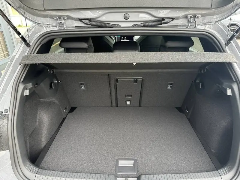 Coffre ouvert vu de l'arrière d'une Volkswagen Golf 2.0 TDI gris, montrant la banquette arrière et la tablette cache-bagages.