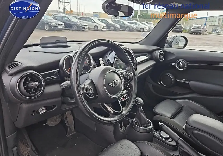 Intérieur noir de MINI Cooper S 2015 vu côté conducteur, avec volant cuir multifonction et tableau de bord rond.