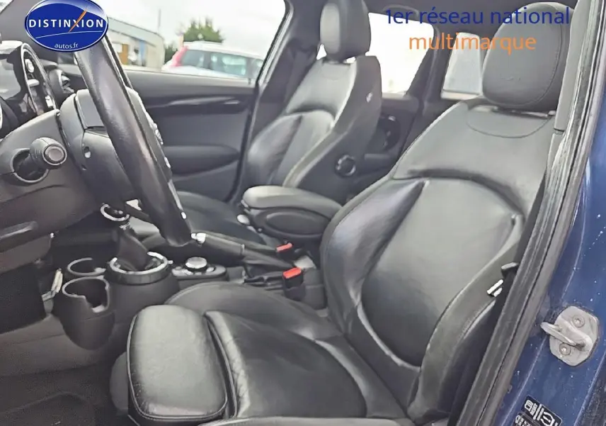 Vue intérieure côté conducteur de la MINI Cooper S 2015 avec sièges sport en cuir noir et portière bleu nuit ouverte.