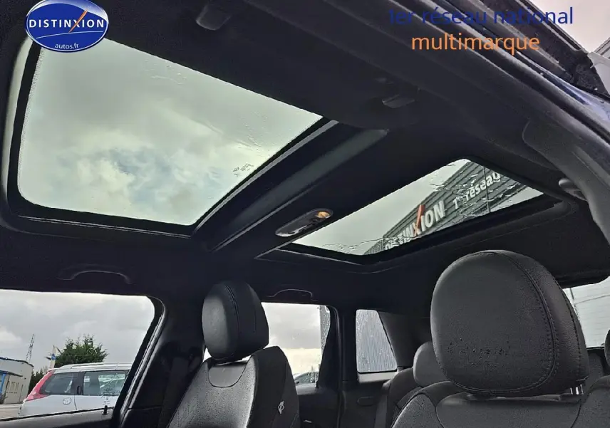 Vue intérieure du toit ouvrant panoramique et des sièges avant en cuir noir d'une MINI Cooper S bleu nuit 2015.