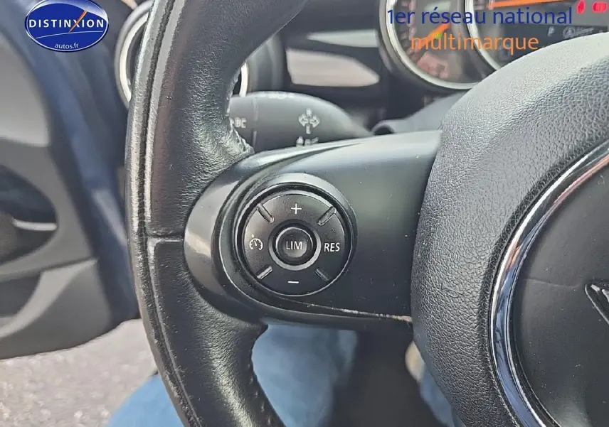 Gros plan sur le volant cuir noir de la MINI Cooper S 2015, avec commandes multifonctions côté gauche.