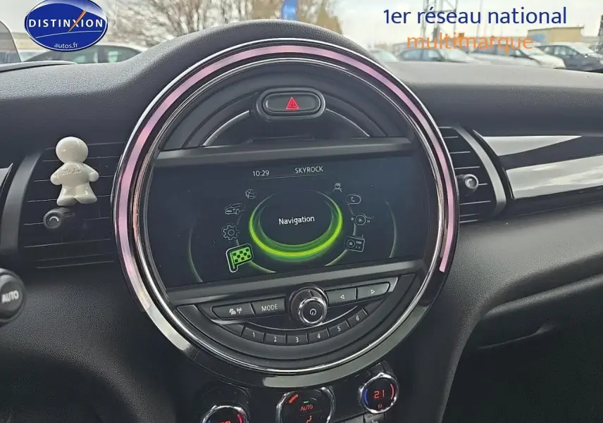 Vue rapprochée du tableau de bord de la MINI Cooper S 2015 avec écran central rond et éclairage d’ambiance rose.