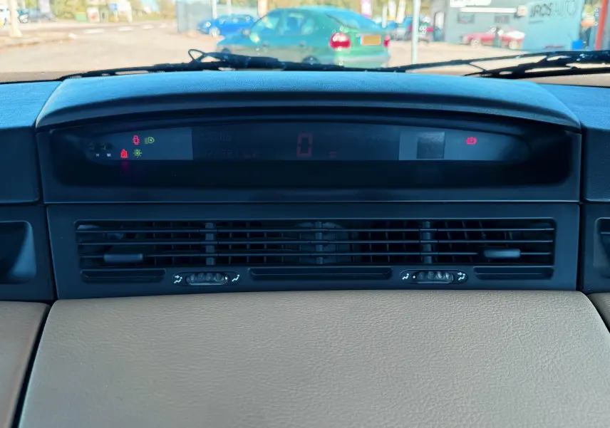 Tableau de bord noir et beige de Renault Avantime 3.0 V6, affichage digital central et aérateurs horizontaux noirs.