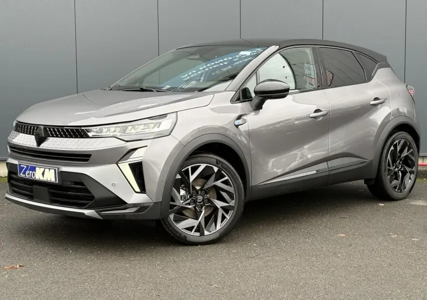 Renault Captur 2025 gris Cassiopée avec toit noir, vue 3/4 avant côté gauche, jantes aluminium 19 pouces Elixir.