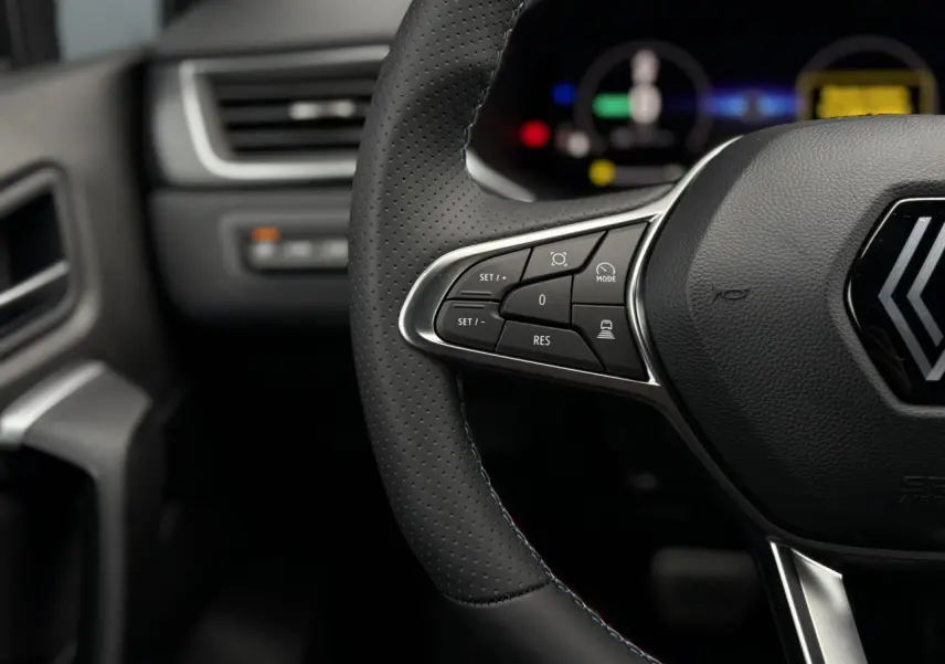 Gros plan sur le volant noir perforé avec surpiqûres tricolores du Renault Captur Esprit Alpine 2025, boutons de régulateur.