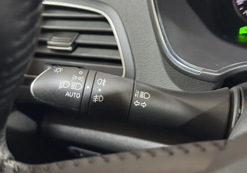 Gros plan sur la commande des phares et clignotants dans l’habitacle de la Renault Mégane Business gris clair.
