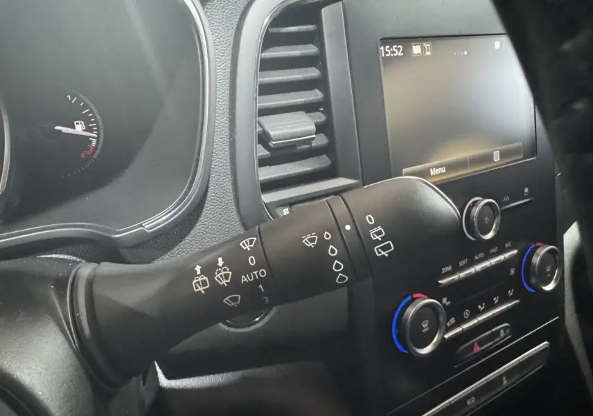 Vue intérieure rapprochée du commodo d’essuie-glace et du tableau de bord noir de la Renault Mégane Business gris clair.