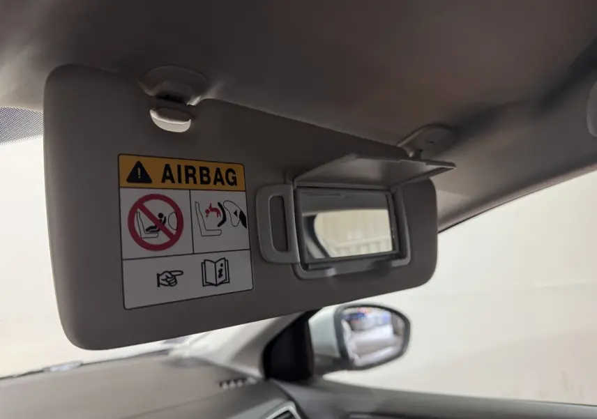 Détail du pare-soleil côté conducteur avec miroir et avertissement airbag, intérieur gris de la Renault Mégane Business.