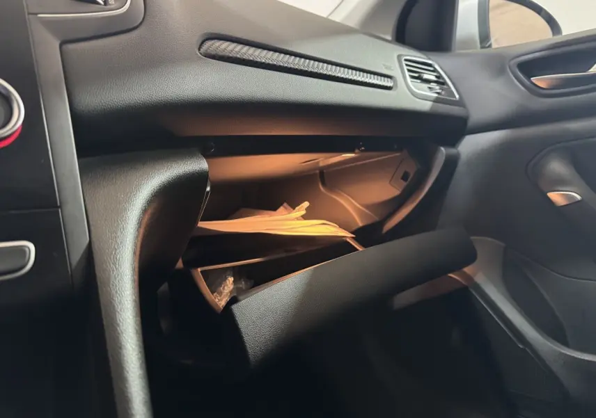 Vue intérieure côté passager de la Renault Mégane Business 2019, boîte à gants ouverte avec documents visibles.
