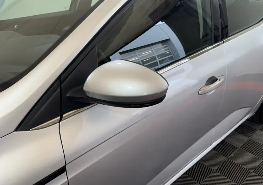 Vue rapprochée du rétroviseur côté gauche d’une Renault Mégane Business gris clair, avec poignée de porte visible.