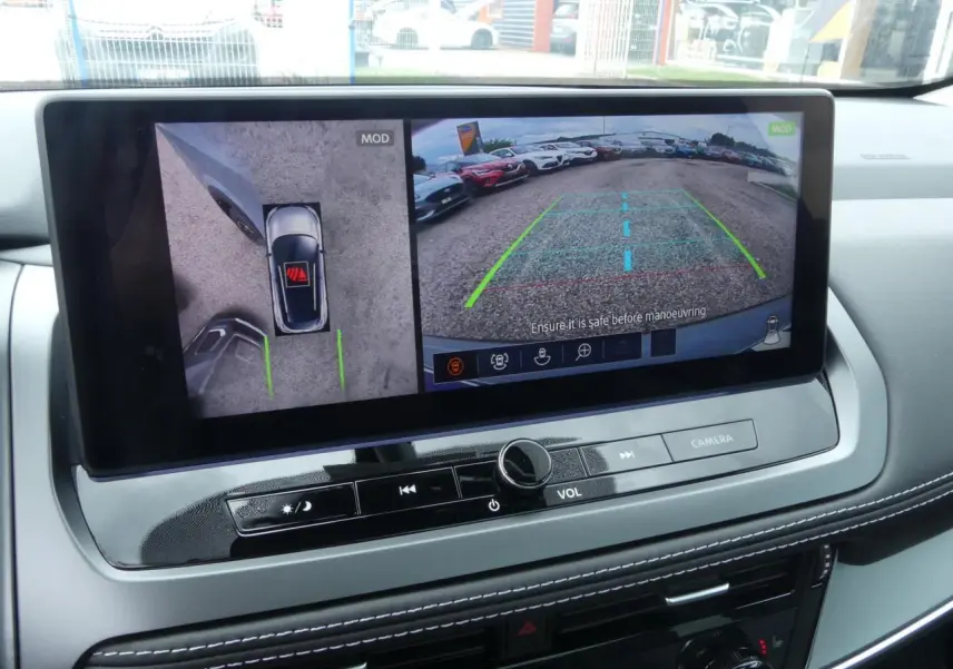 Vue intérieure sur l'écran multimédia affichant la caméra 360° et l'aide au stationnement du Nissan Qashqai gris métallisé.