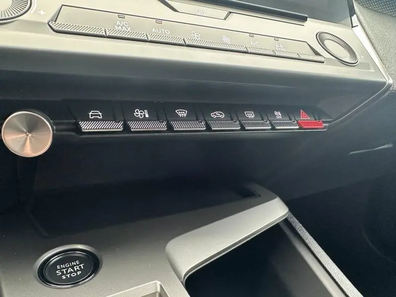 Gros plan sur la console centrale de la Peugeot 308 2024 noir Perla Nera, montrant les boutons de commande et le bouton start/stop.