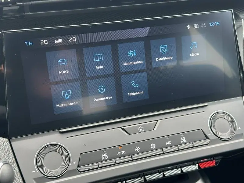 Écran tactile central de la Peugeot 308 2024 affichant les menus ADAS, climatisation et médias, avec commandes en dessous.