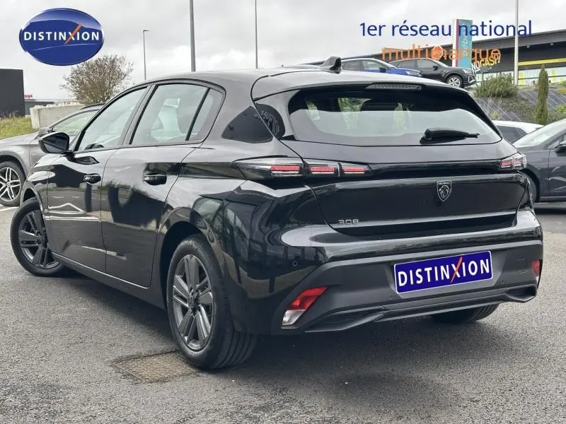 Peugeot 308 2024 noir Perla Nera vue 3/4 arrière droit, feux arrière à LED et jantes alliage visibles.