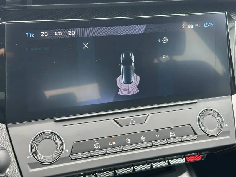 Écran tactile central de la Peugeot 308 2024 noir Perla Nera montrant l'aide au stationnement et commandes climatisation.
