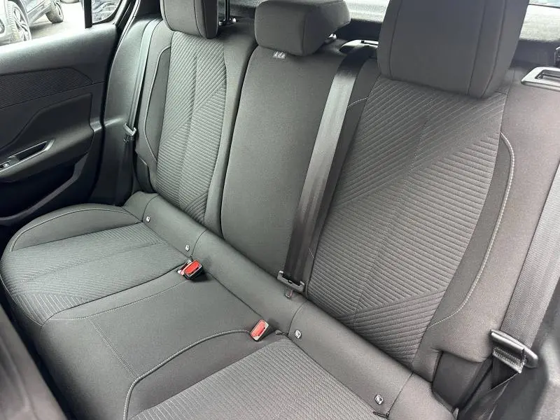 Vue intérieure montrant la banquette arrière noire avec sellerie tissu et ceintures de sécurité dans une Peugeot 308 2024.