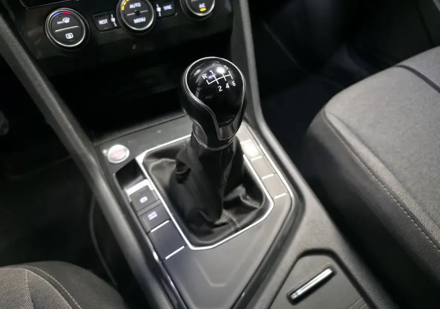 Gros plan sur le levier de vitesses manuel noir et la console centrale du SEAT Tarraco gris, avec commandes climatisation visibles.
