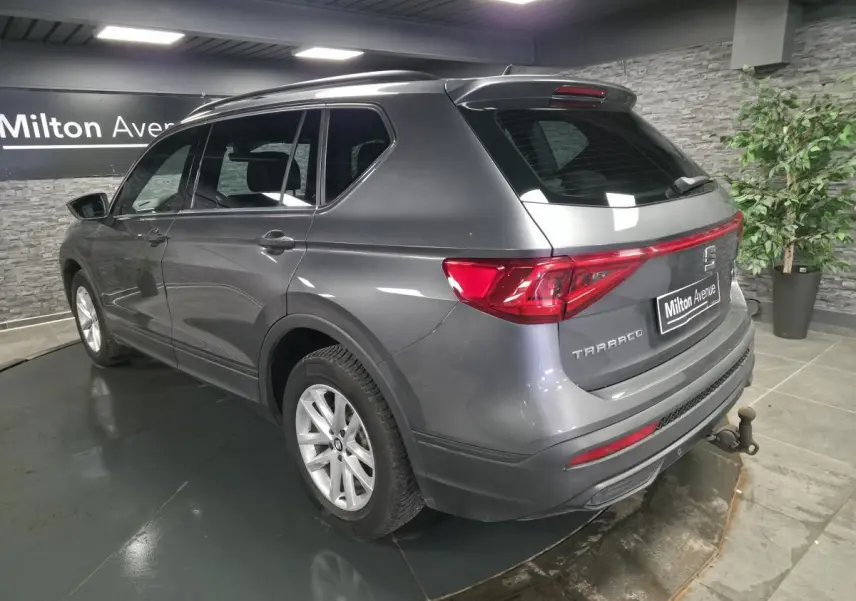 Vue 3/4 arrière droite du SEAT Tarraco gris avec crochet d'attelage escamotable et vitres surteintées.