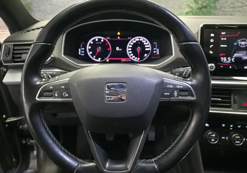 Vue rapprochée du volant cuir multifonction noir du SEAT Tarraco 2020 avec tableau de bord digital et écran tactile.