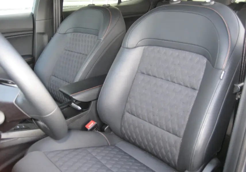 Gros plan sur les sièges avant en cuir noir avec surpiqûres orange de la MG3 1.5 Hybrid Luxury 2025.