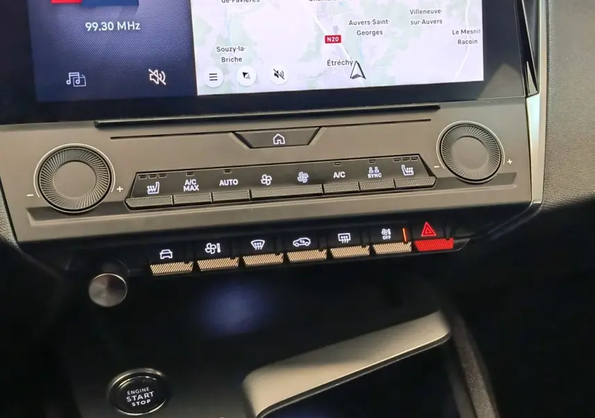 Gros plan sur la console centrale de la Peugeot 308 verte, montrant l'écran tactile et les commandes climatisation et démarrage.