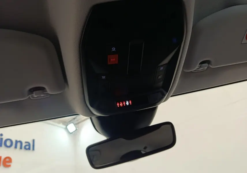 Vue intérieure du plafond avant de la Peugeot 308 2023, montrant le panneau de commandes avec bouton SOS rouge et rétroviseur central.