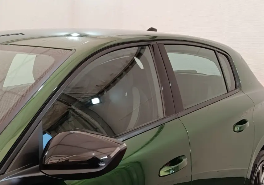 Vue latérale gauche rapprochée d’une Peugeot 308 2023 vert métallisé avec rétroviseur noir brillant.
