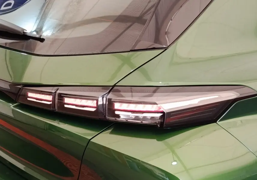 Gros plan sur le feu arrière droit rouge et blanc d'une Peugeot 308 2023 vert métallisé.