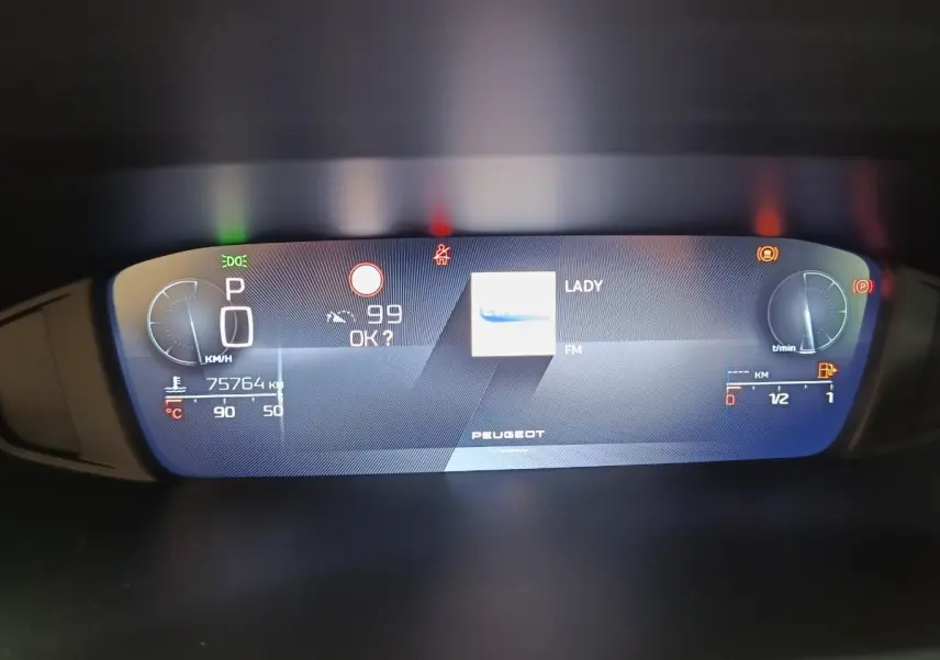 Affichage numérique du tableau de bord de la Peugeot 308 2023, avec vitesse, température et radio FM visible.