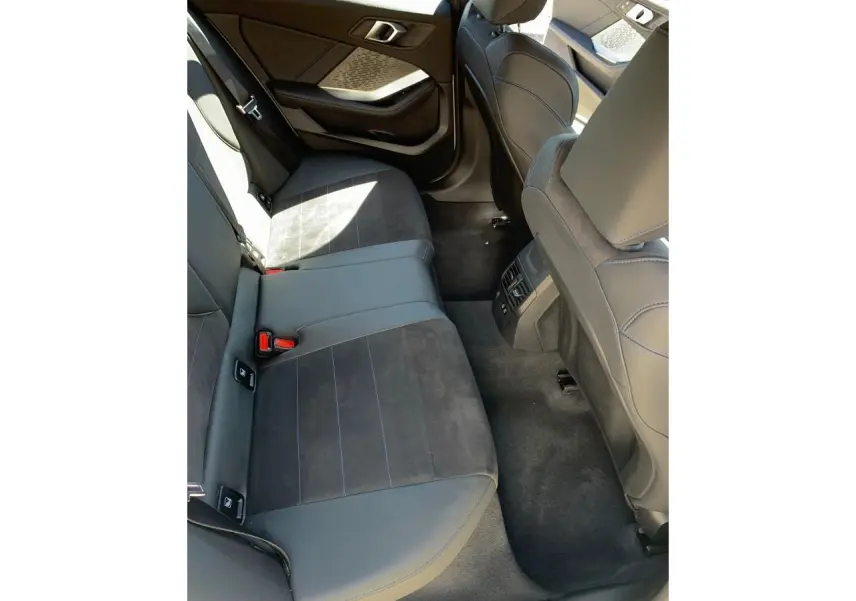 Vue intérieure côté gauche des sièges arrière en Alcantara noir et cuir avec surpiqûres bleues d'une BMW Série 1 118D M Sport 2025.