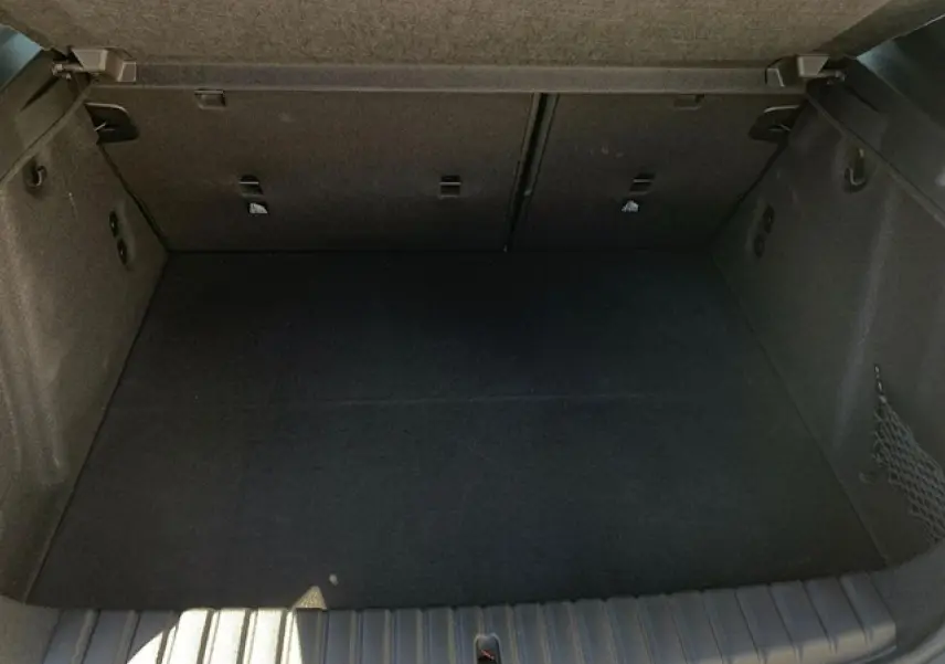 Coffre spacieux de BMW Série 1 118D M Sport 2025, vue intérieure avec filet côté droit et crochets porte-sacs.