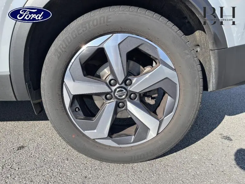 Gros plan sur la jante alliage gris foncé du Nissan Qashqai 1.3 Mild Hybrid 140ch Tekna, détail du pneu Bridgestone.