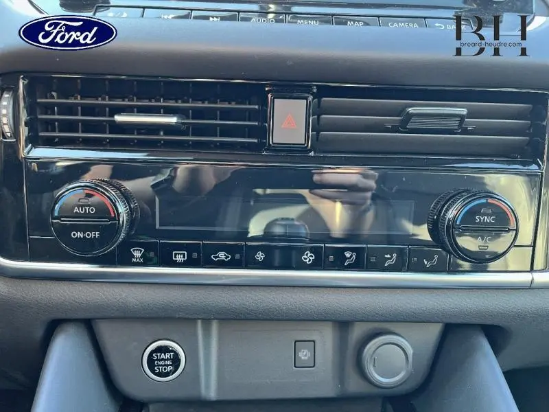 Tableau de bord noir brillant du Nissan Qashqai 1.3 Mild Hybrid 2022 avec commandes climatisation et bouton démarrage visible.