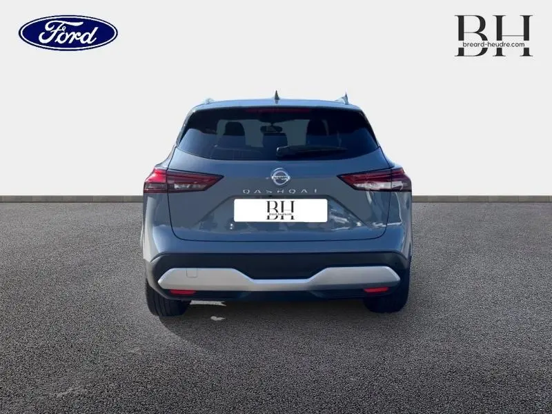 Vue arrière du Nissan Qashqai 1.3 Mild Hybrid 140ch Tekna en gris Argile avec feux arrière LED et lunette teintée.