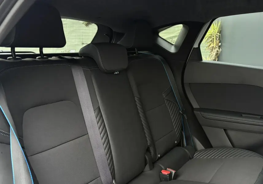 Vue intérieure sur la banquette arrière noire avec surpiqûres bleues du Renault Captur Blanc Nacré 2025 Esprit Alpine.