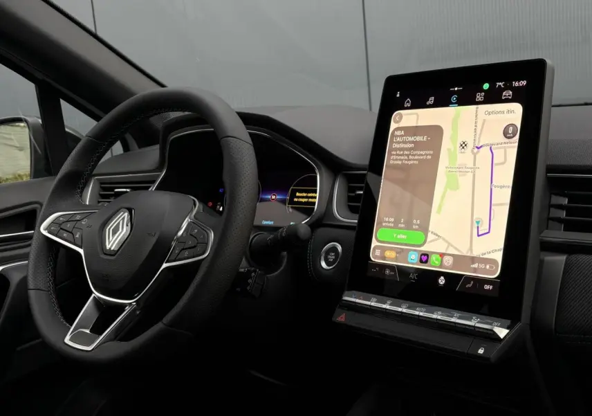 Vue intérieure du tableau de bord du Renault Captur blanc nacré avec écran tactile vertical et volant multifonction.