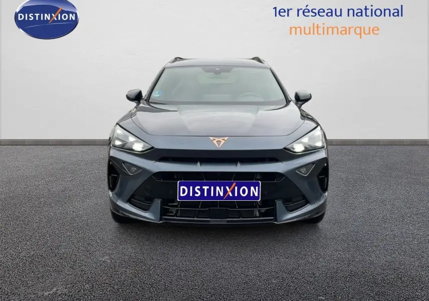 Vue frontale d'un CUPRA Formentor gris magnétique métallisé avec logo cuivré et phares LED allumés.