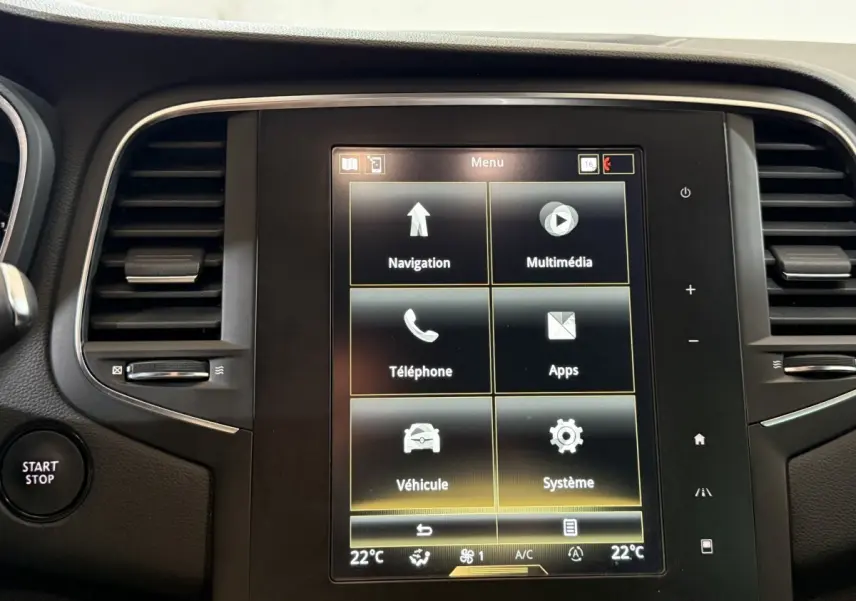 Écran tactile central de la Renault Mégane Intens gris foncé, avec menu multimédia et bouton Start/Stop visible à gauche.