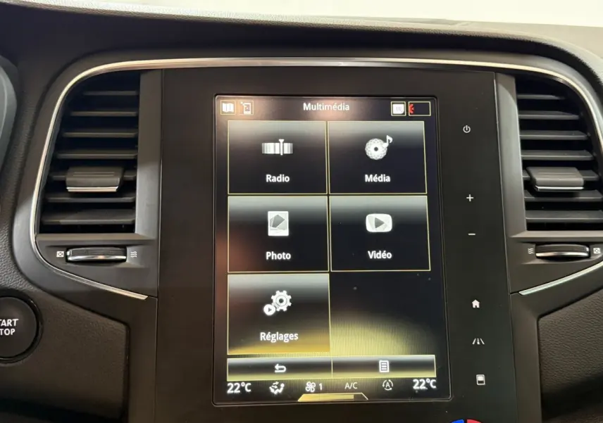 Écran tactile central multimédia de la Renault Mégane Intens gris foncé, avec commandes climatisation et ventilation visibles.