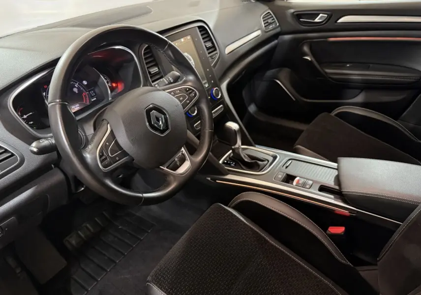 Vue intérieure côté conducteur de la Renault Mégane Intens 2019, volant cuir et console centrale avec boîte auto.