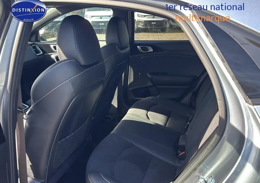 Vue intérieure côté droit montrant la banquette arrière et les sièges avant en cuir noir du KIA Xceed gris 2024.
