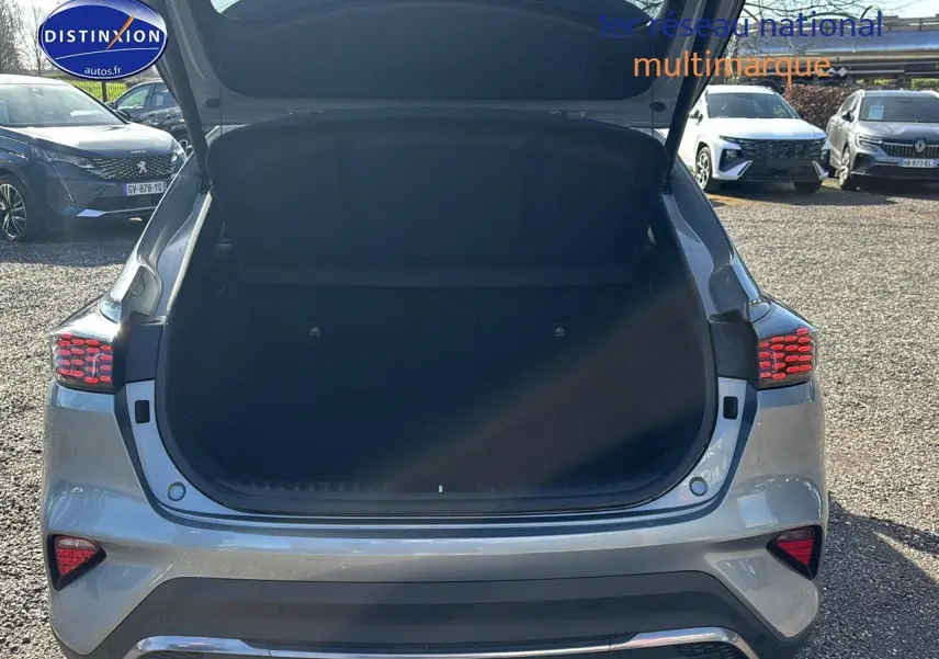 Vue arrière d’un KIA Xceed gris 2024 avec coffre ouvert, feux arrière LED allumés et becquet visible.