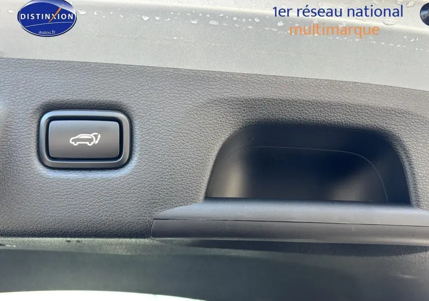 Bouton d'ouverture électrique du coffre sur la garniture intérieure d'un Kia Xceed gris 2024.