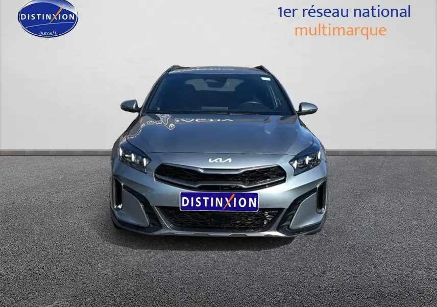 Vue avant d'un KIA Xceed gris 2024 avec calandre noire et phares LED distinctifs, sur fond neutre.
