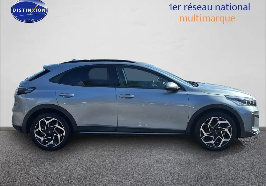 Profil droit d'un KIA Xceed gris 2024 avec jantes alliage au design géométrique et vitres arrière surteintées.