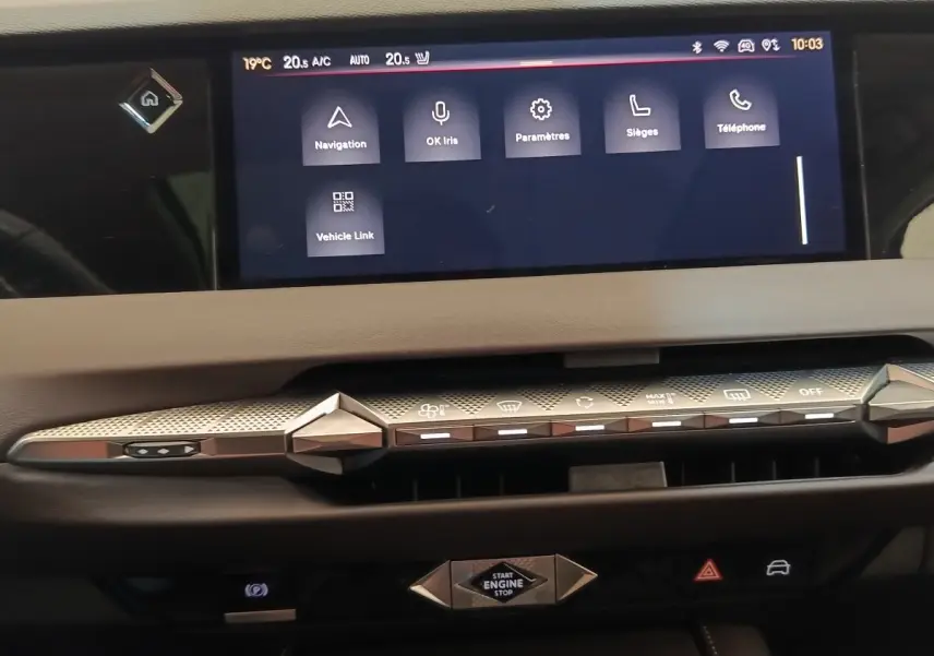 Vue rapprochée du tableau de bord gris clair de la DS4 E-TENSE 225 avec écran tactile et commandes design géométriques.